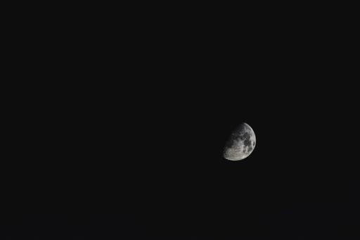 A view of the half of the moon in the sky captured on a clear night without clouds