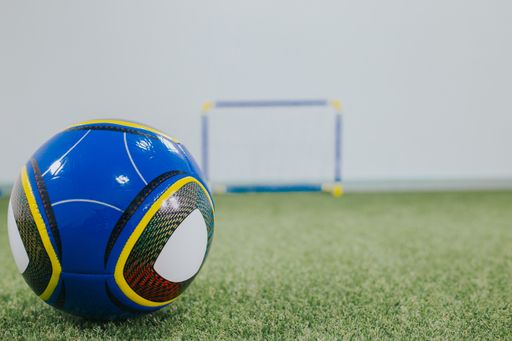 A selective focus shot of a blue soccer ball in a children's playground