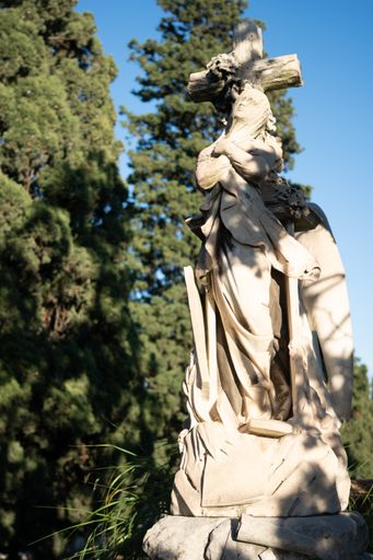 A vertical shot of an old statue in Montjuic Cemetery, Barcelona, Spain