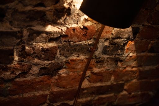 A beautiful shot of a wall made of bricks and a lamp lightening it
