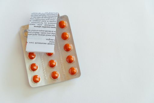 A top view of medical pills and a medication guide isolated on a white background