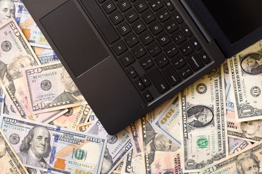 Flat lay of a notebook on dollar bills