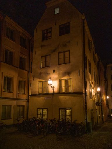 A beautiful shot of a building at night with parked bicycles in front of it