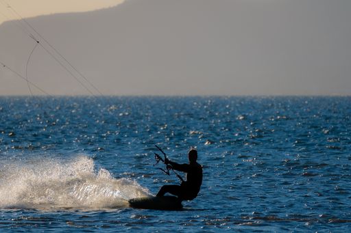 A female kite surfer in the sunset