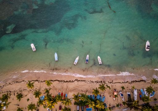 A beautiful overhead shot of sea coast with some small boats parked near the shore
