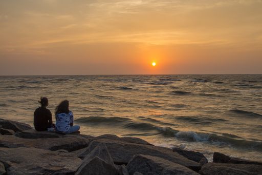 The girls enjoying the mesmerizing view of the sunset over the sea