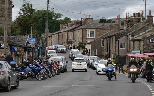 The main street through the town of Hawes, North Yorkshire, the UK, with bikers driving on a Sunday afternoon