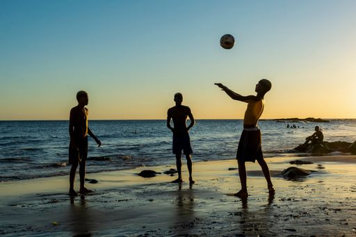 A group of young people playing sand football at sunset on Ondina beach in Salvador, Brazil