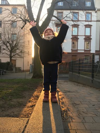 A beautiful vertical picture of a kid standing against sunlight in outdoor