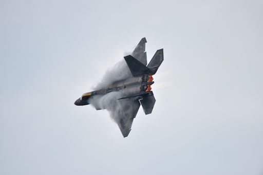 A USAF F-22 Aircraft with afterburner and vapor