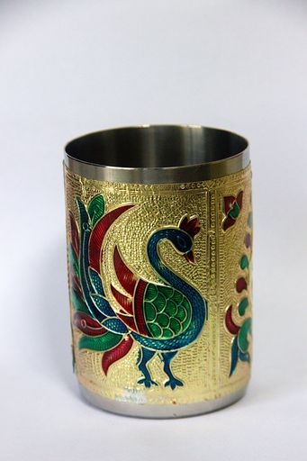 A vertical shot of a cylindrical, etched, and painted pen stand on a white background.