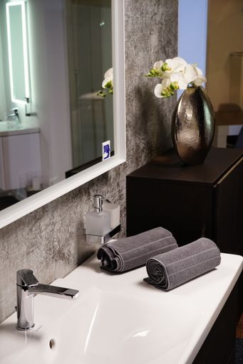 A vertical picture of a bathroom with towels and beautiful decoration in a hotel
