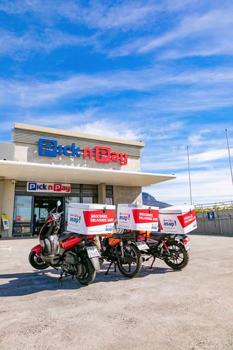 A vertical shot of Express Service delivery bikes parked outside local Pick n Pay grocery store