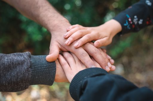 A closeup of the hands of people on each other under the sunlight at daytime