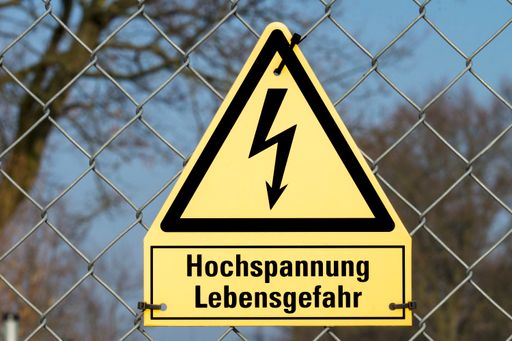 A high voltage danger sign in German on a mesh