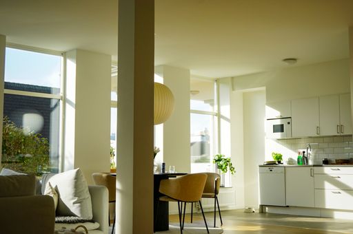 A white modern and lightfull apartment interior with big windows.