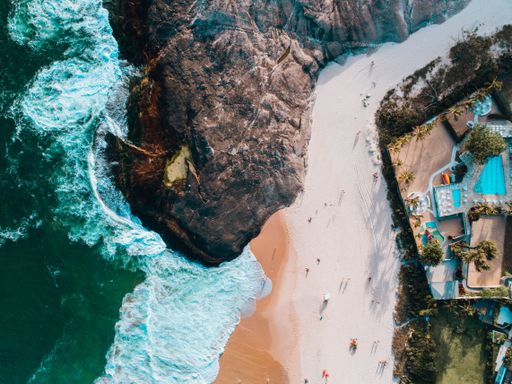 An aerial shot of a beach in Rio de Janeiro with houses on the mountain