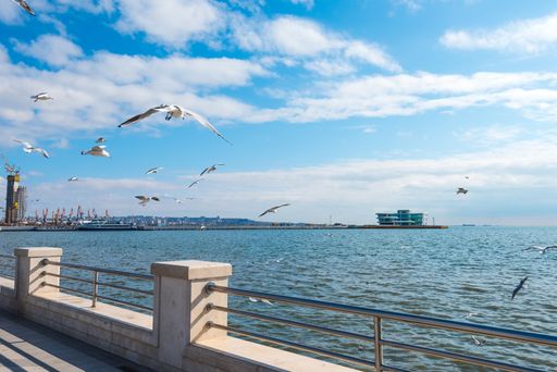 A beautiful view of a long fence near the Fountains in Seaside Park, Baku, Azerbaijan with a cloudy sky