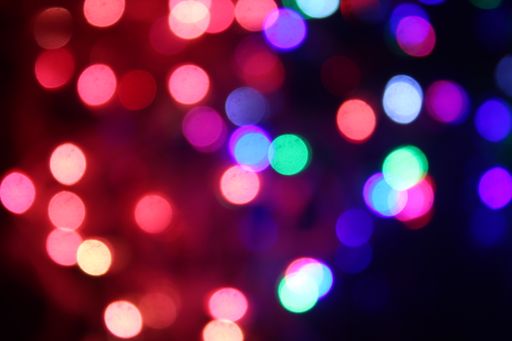 An abstract background of colorful LED lights with bokeh effect glowing at night