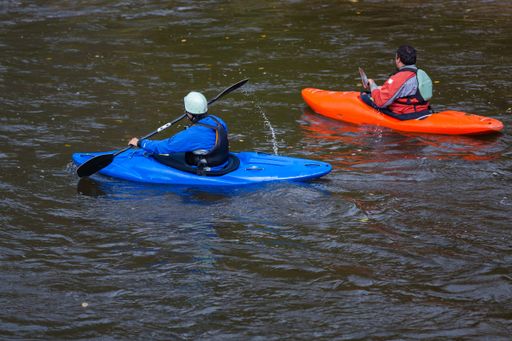 A closeup shot of kayakers in blue and orange boats on the Youghiogheny River near Friendsville