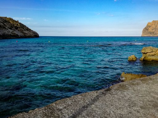 A beautiful scene of a calm sea and rocky cliffs during the daytime