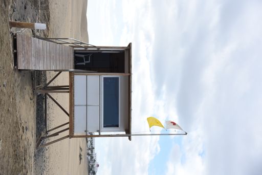 A vertical shot of a watchtower at the beach