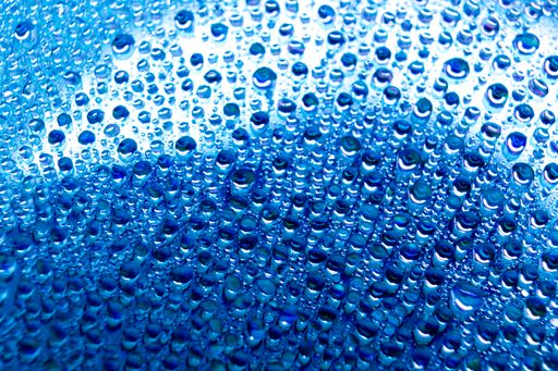 A selective focus shot of colorful reflective water drops on a digital disc surface. various RGB LED lights illuminate the scene.
