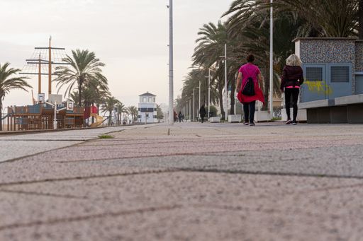The view of walking people along the beach promenade of Gandia