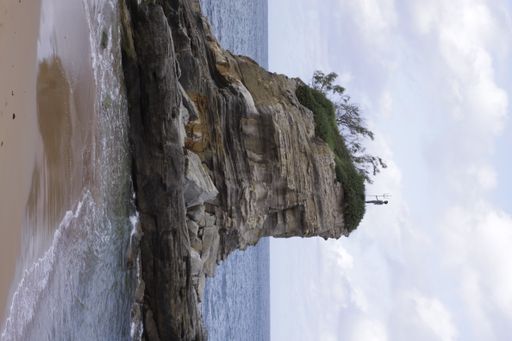 A beautiful view of the rocky small cliff on the sandy beach in Spai