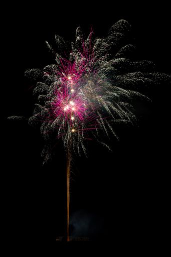 A vertical shot of fireworks blowing up at night