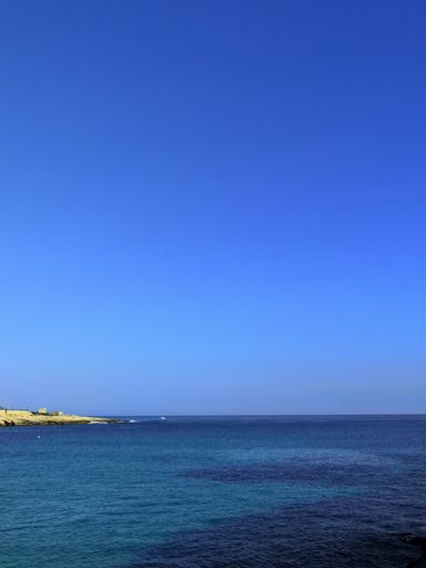 a vertical shot of a calm, beautiful beach in Malta captured on a bright, sunny day