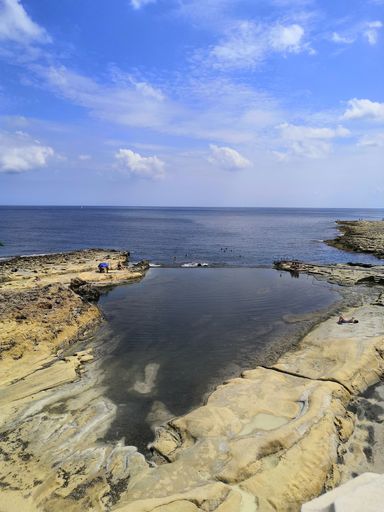 a vertical shot of a calm, beautiful beach in Malta captured on a bright sunny day