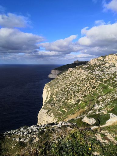 a vertical shot of the beautiful cliffs with the calm sea in Siggiewi, Malta captured on a sunny day