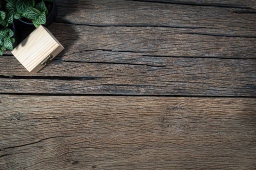 A top view of a wooden desk with potted plants and a wooden box along with copy space