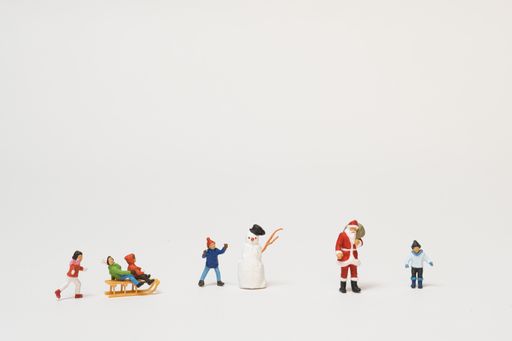 A Christmas scene of miniature figures of kids and Santa Claus playing in the snow