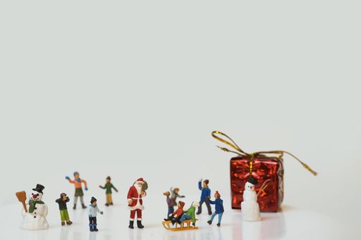 A Christmas scene of miniature figures of kids and Santa Claus playing in the snow