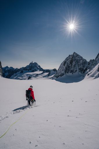 Mountaineering in snow covered mountains of Mont Blanc. Ascent on a glacier with a rope and ice axe. Winter adventure.