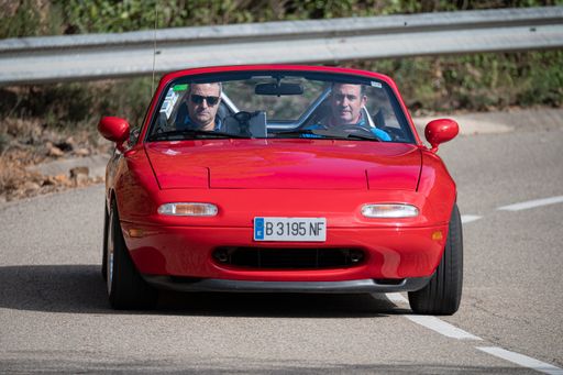 A man driving Mazda MX-5 NA VIII Rallye on a highway in Catalonia, Spain