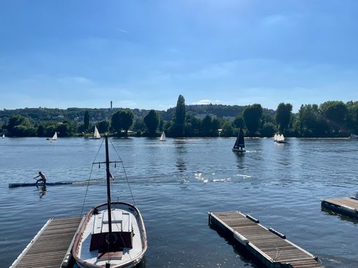 A rower on the Vltava river in Prague Podol during a beautiful sunny day.