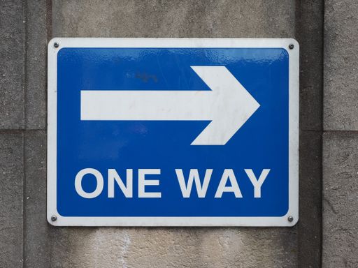 A one way traffic sign on a wall