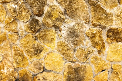 Background of dark yellow brown rough stone wall texture horizontal photo. Stone pattern, textures and backgrounds
