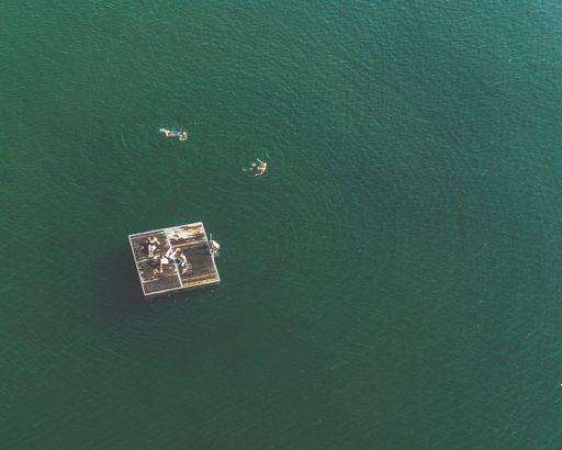An aerial view of a board in the sea and people swimming