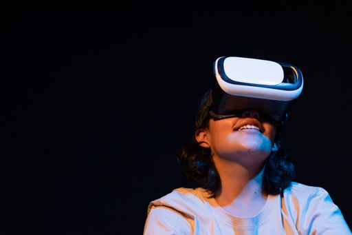 A young Hispanic female experiencing virtual reality for the first time on a black background