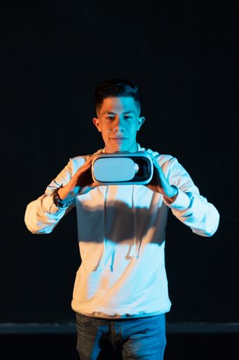 A young Hispanic male experiencing virtual reality for the first time on a black background