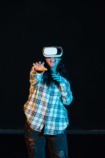A young Hispanic female experiencing virtual reality for the first time on a black background