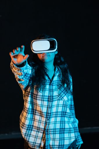 A young Hispanic female experiencing virtual reality for the first time on a black background