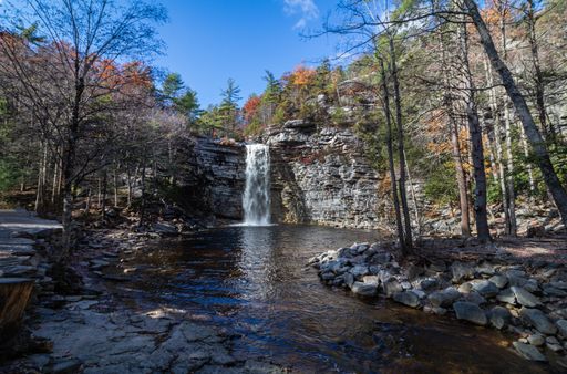 A scenic shot of a waterfall surrounded by a forest in Minnewaska State Park, NY, Kerhonkson, USA