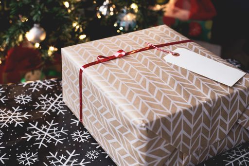 A selective closeup shot of a Christmas decorated gift box with a blank tag as a space for your text