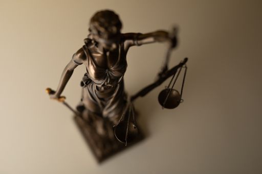 A high angle shot of a sculpture with scales as a law justice symbol