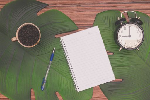 A top view of Notebook and coffee mug On the desk